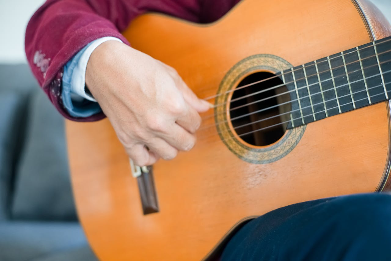 Detailed view of a person strumming an acoustic guitar, showcasing skill and musical expression.