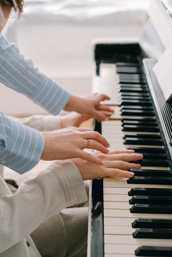 Close-up of adult hands playing piano keys, showcasing musical practice and skill.